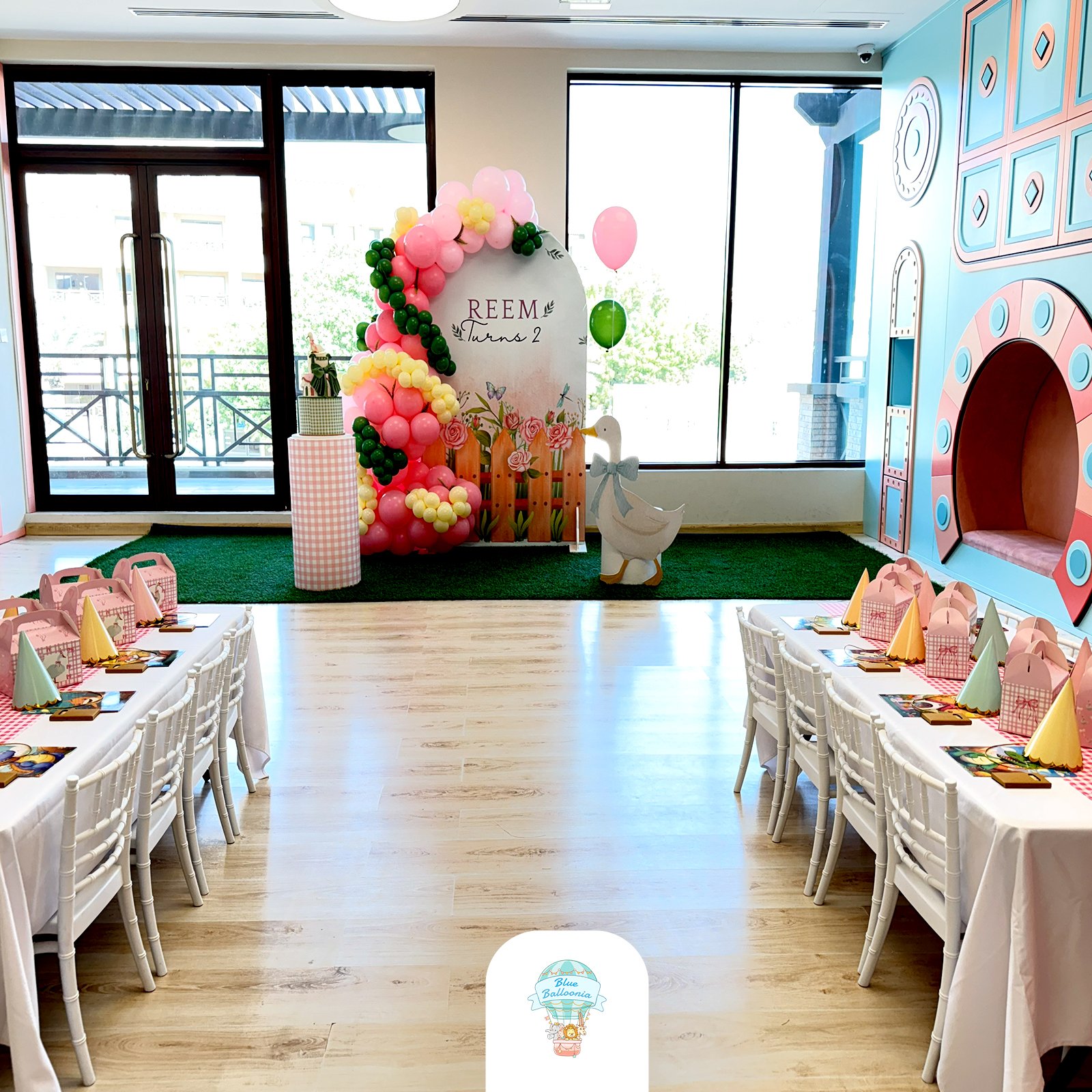 Party Hall tables facing a balloon backdrop