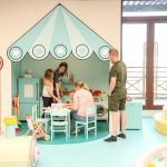 Adults and children playing together in BlueBalloonia’s pretend-play area